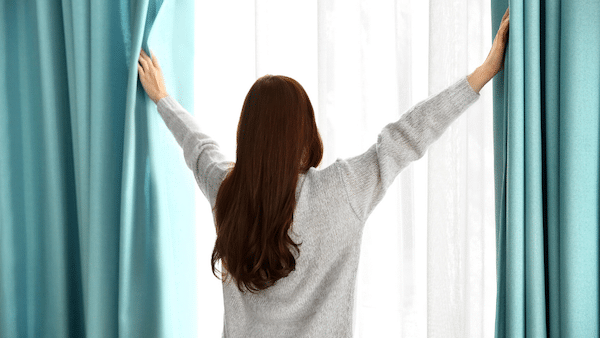 Woman closing curtains