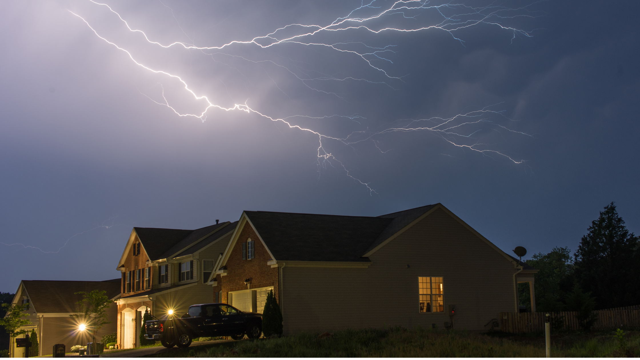 Lightning striking across the sky above a home | Value of a Whole-House Generator