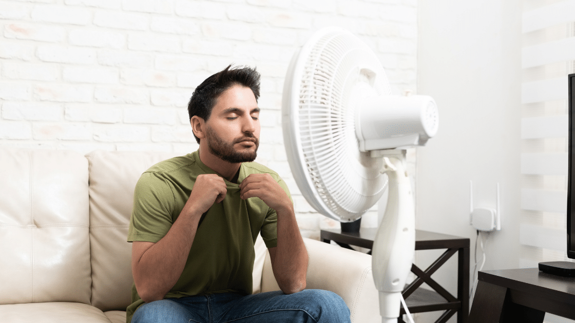 Man sitting in front of fan