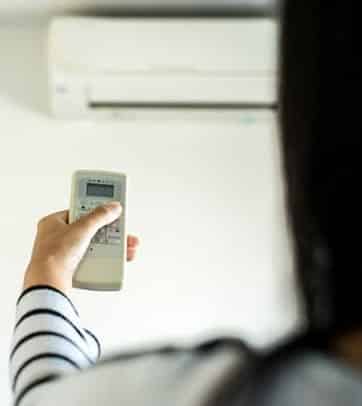 Woman with remote to mini split system