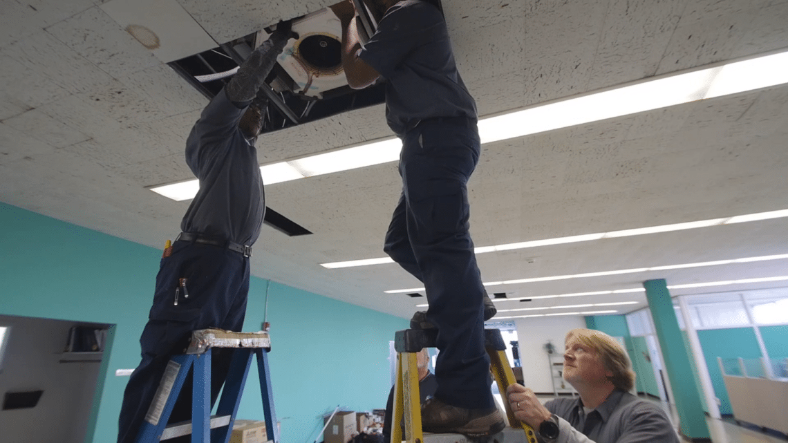 HVAC technicians installing HVAC unit